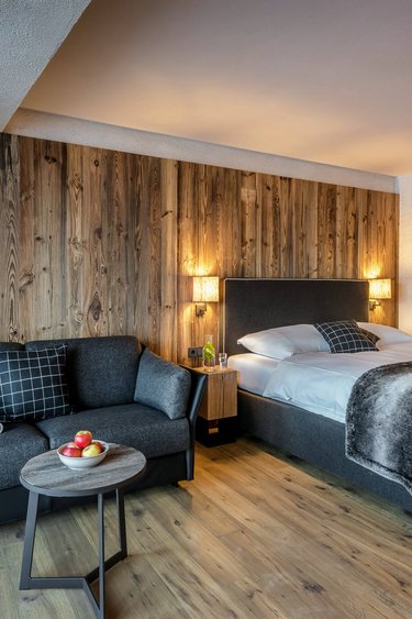 Zimmer mit Bett und Sitzecke in Grau Apartment Friedl