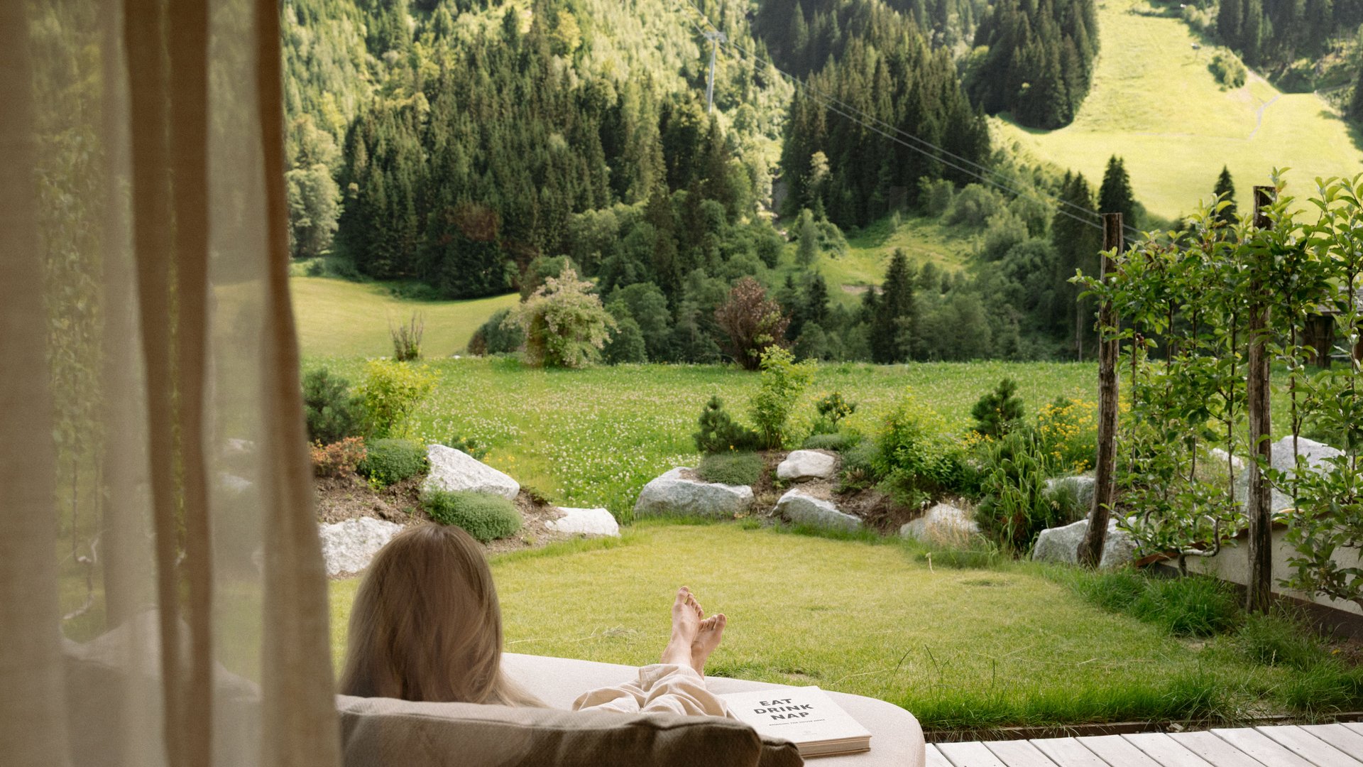 Dame liegt auf Terrasse mit Blick in den Garten