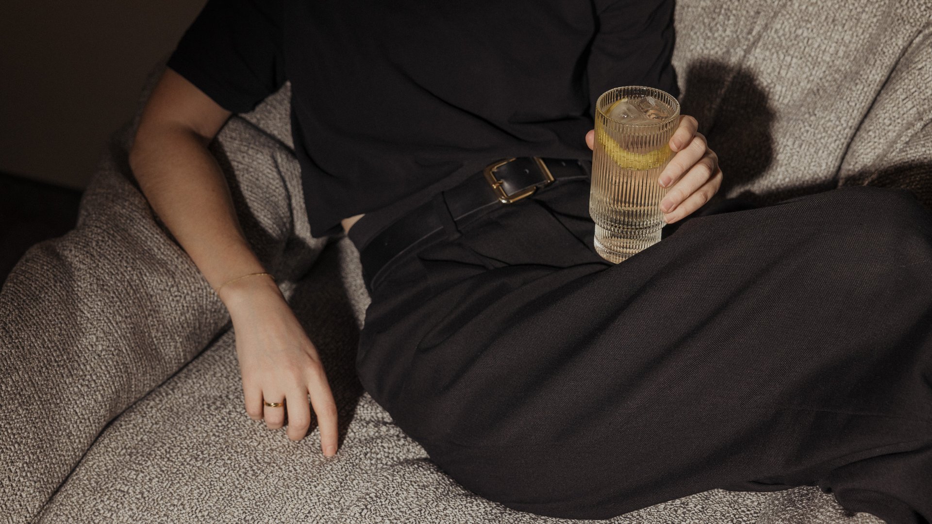 Dame entspannt auf Couch mit Glas in der Hand