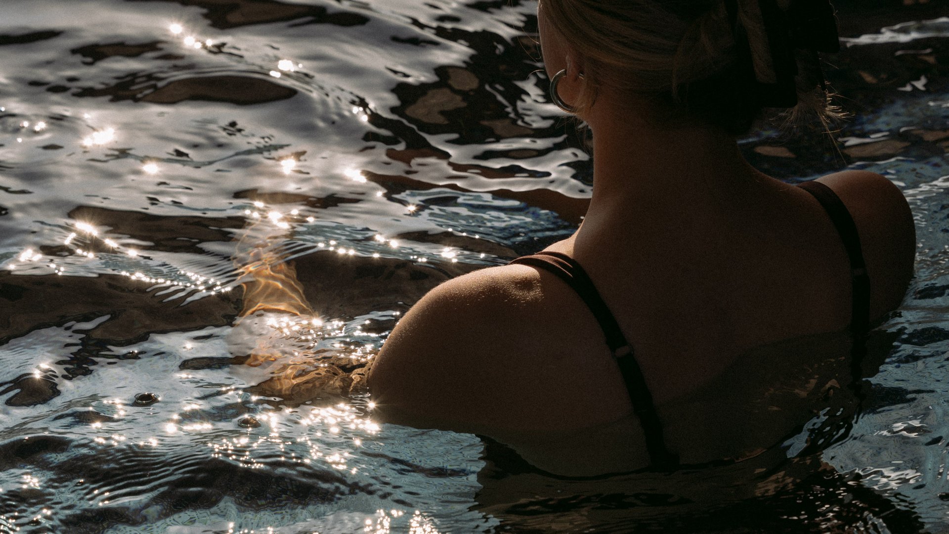 Dame mit hochgesteckten Haaren in dunklem Wasser